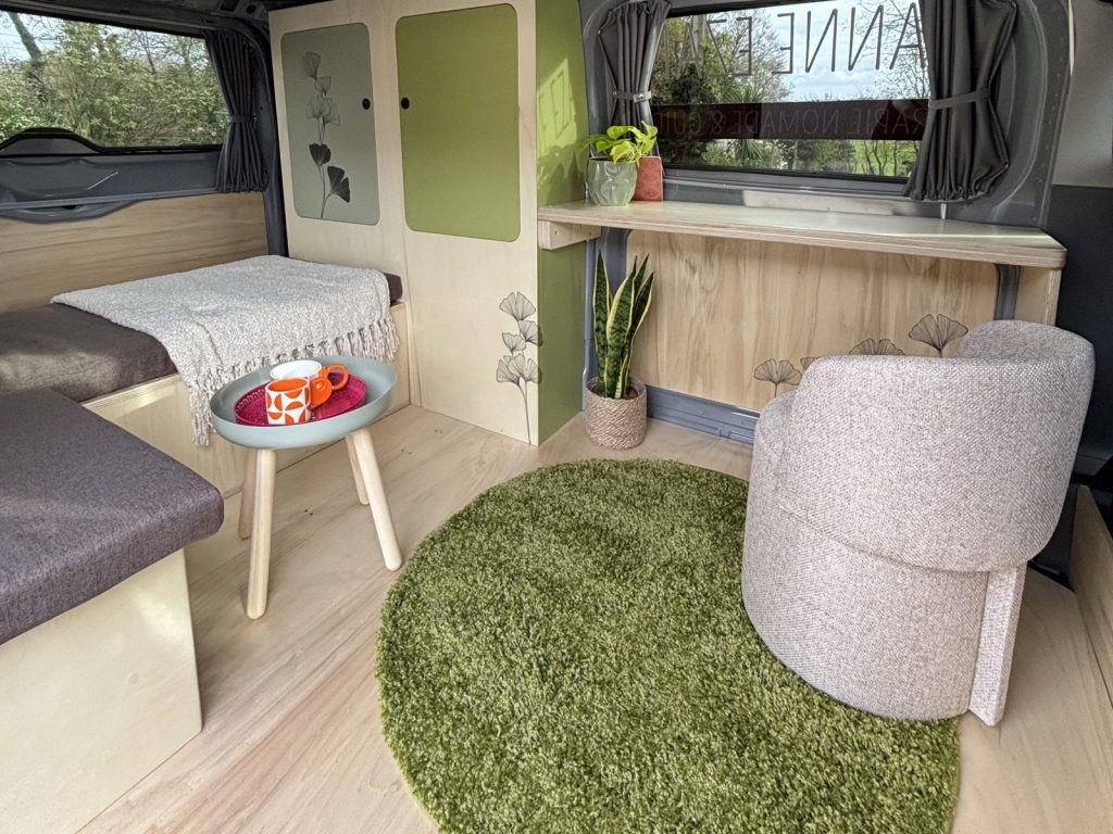 Intérieur du van aménagé de Jeanne Ezanno : fauteuil, tapis vert et coin bureau pour les consultations
